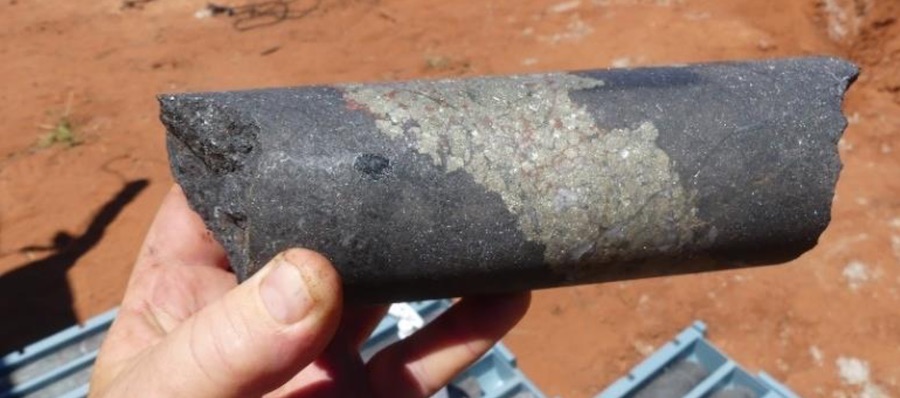 Drill core displaying massive magnetite skarn with disseminated scheelite and molybdenite mineralisation and bands of chalcopyrite